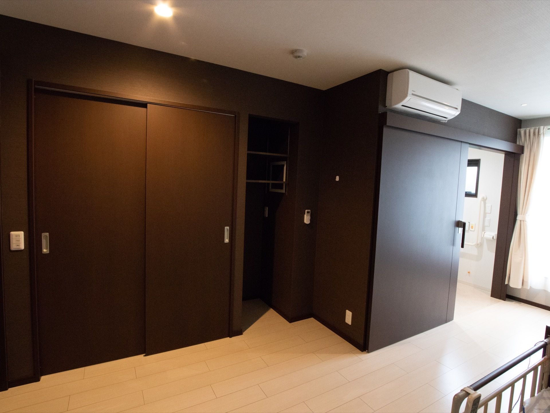 居室にはクロゼットが用意されている。天井近くにエアコンが設置されている。エアコンの下のドアはトイレに繋がっている。