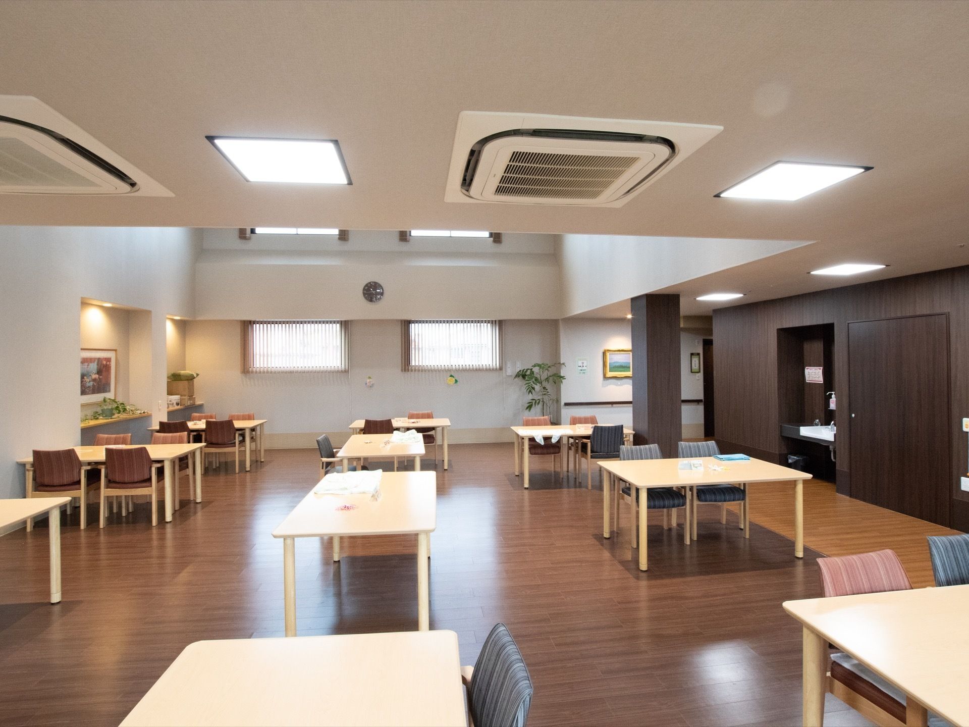 広々とした共有スペースにはテーブルと椅子がいくつも並んでいる。2階まで天井が吹き抜けになっているので開放感がある。