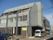 施設は、グレーとブラウンが基調の落ち着いた雰囲気の建物である。３階建てになっており、目の前に車を置くことができるスペースがある。