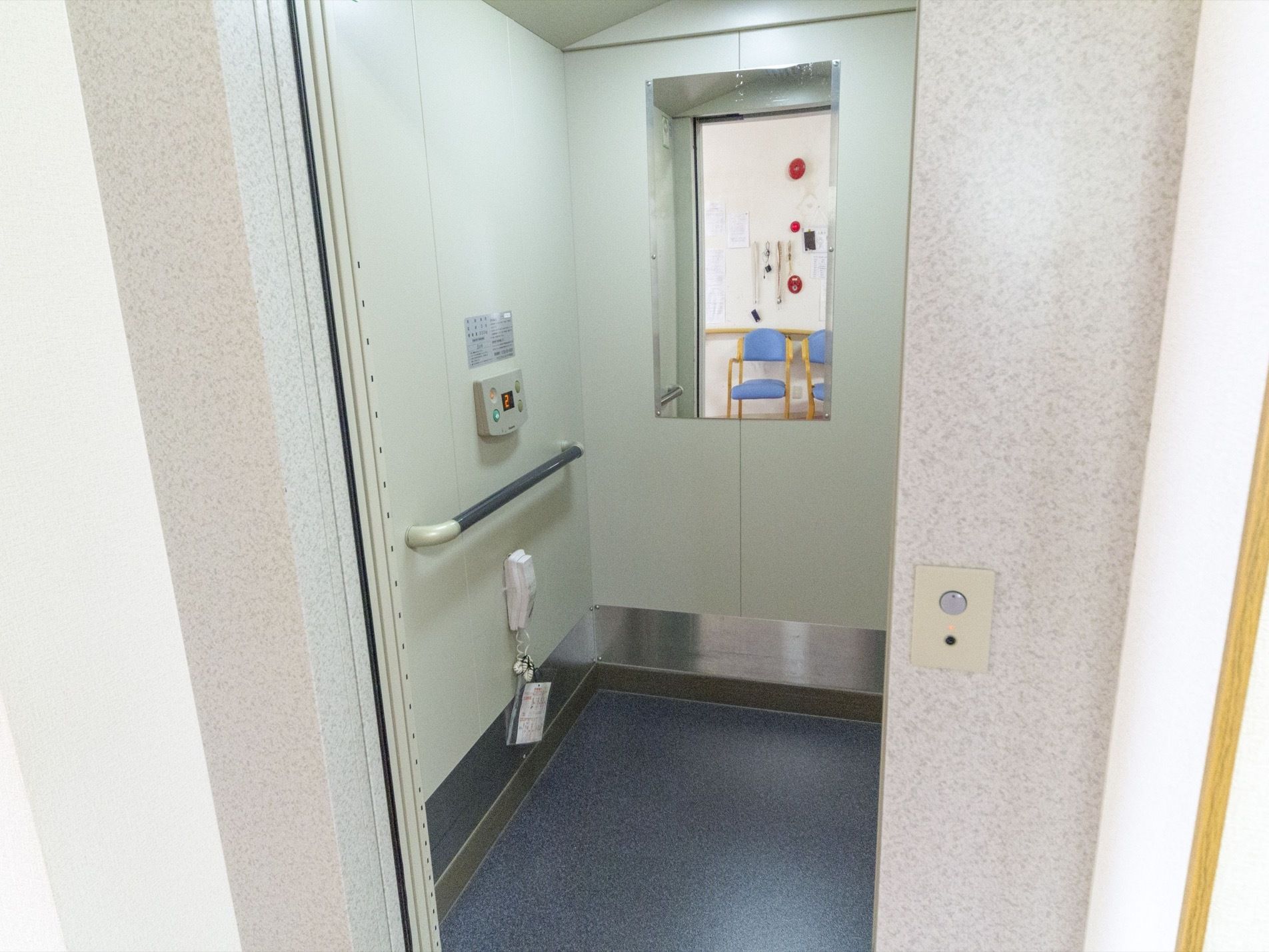 扉の右にボタンがついている。エレベーターの中には鏡が取り付けてある。内側の壁についたボタンの下に手すりが設置されている。