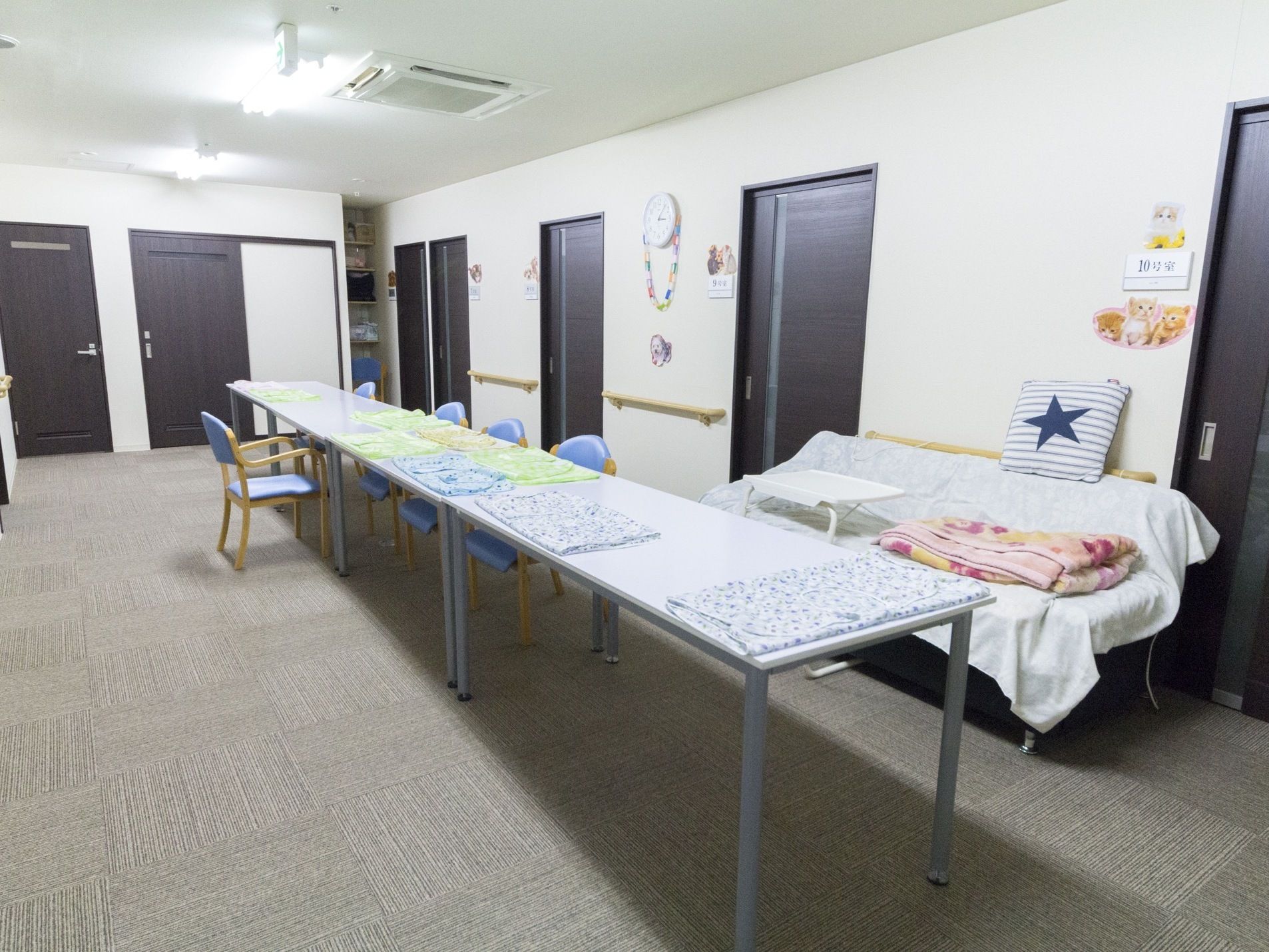 3つのテーブルを細長く配置しており、ゆったり椅子に座ってくつろぐことができるスペースである。壁に時計や手すりが設置されている。