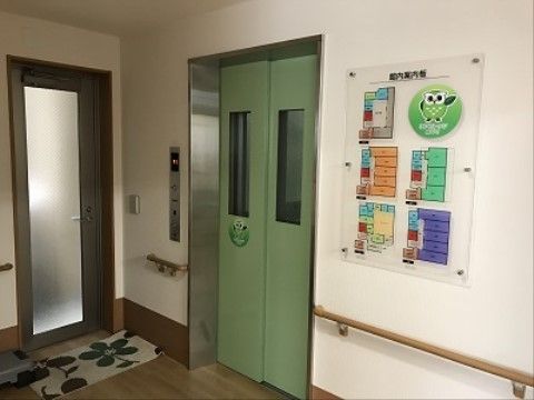 エレベーターの待機スペースには壁面に手すりが付いている。また、エレベーター扉の横にはガラス戸があり出入口の床には花柄のマットが敷かれている。