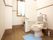 スペースにゆとりがあるトイレである。可動式の背もたれとひじ掛けを設置しており、立ち座りの際に体を支えることができる。