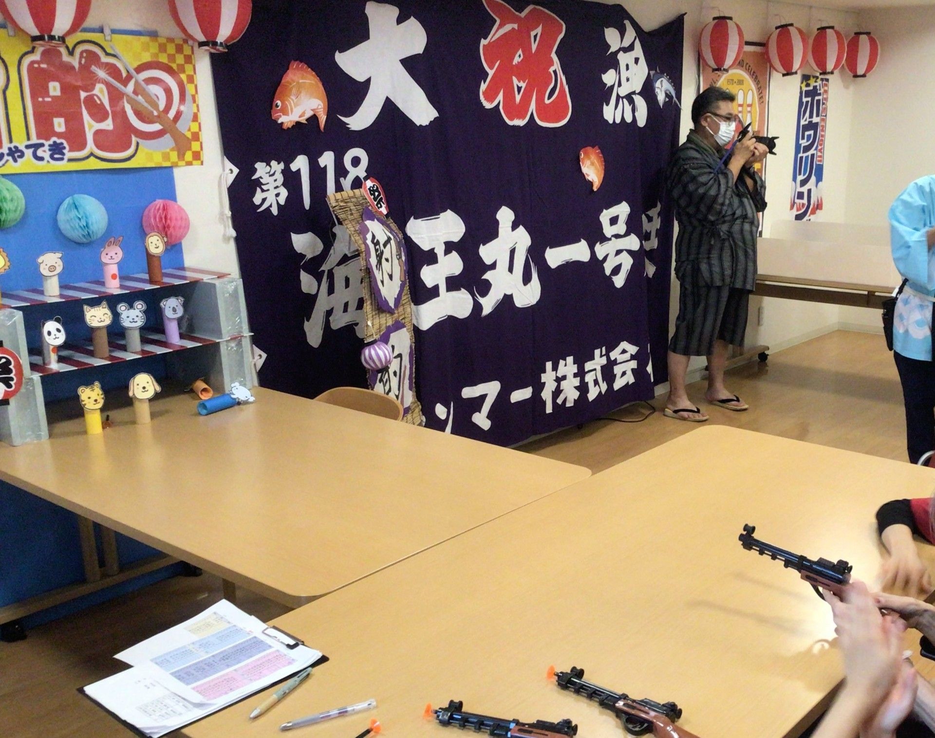 入居者の前でブランドピアノを弾きながら歌う女性と、サンタクロースの衣装を着た人