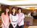 施設の中で、３人の女性スタッフが並んで立っている。背景にはラウンジの入り口があり、天井には照明設備が完備されている。