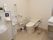 白色と茶系の内装のトイレである。便器横には手すりを設置し、前方の壁際には、チャイルドシートを備えている。床上には、小さなごみ箱を置いている。