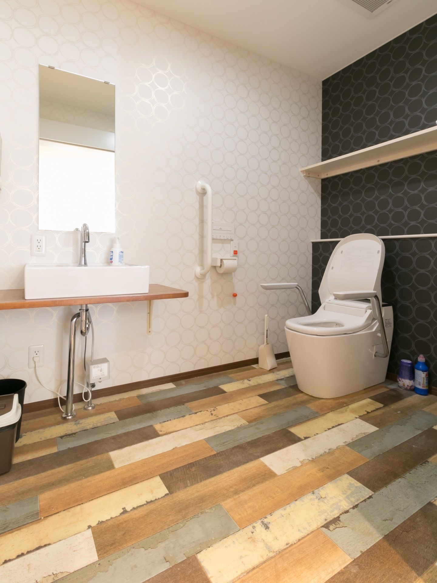 広いスペースに洋式トイレを設置している。呼び出しボタンがあり、いざという時も安心である。自動水栓を採用した洗面台がある。