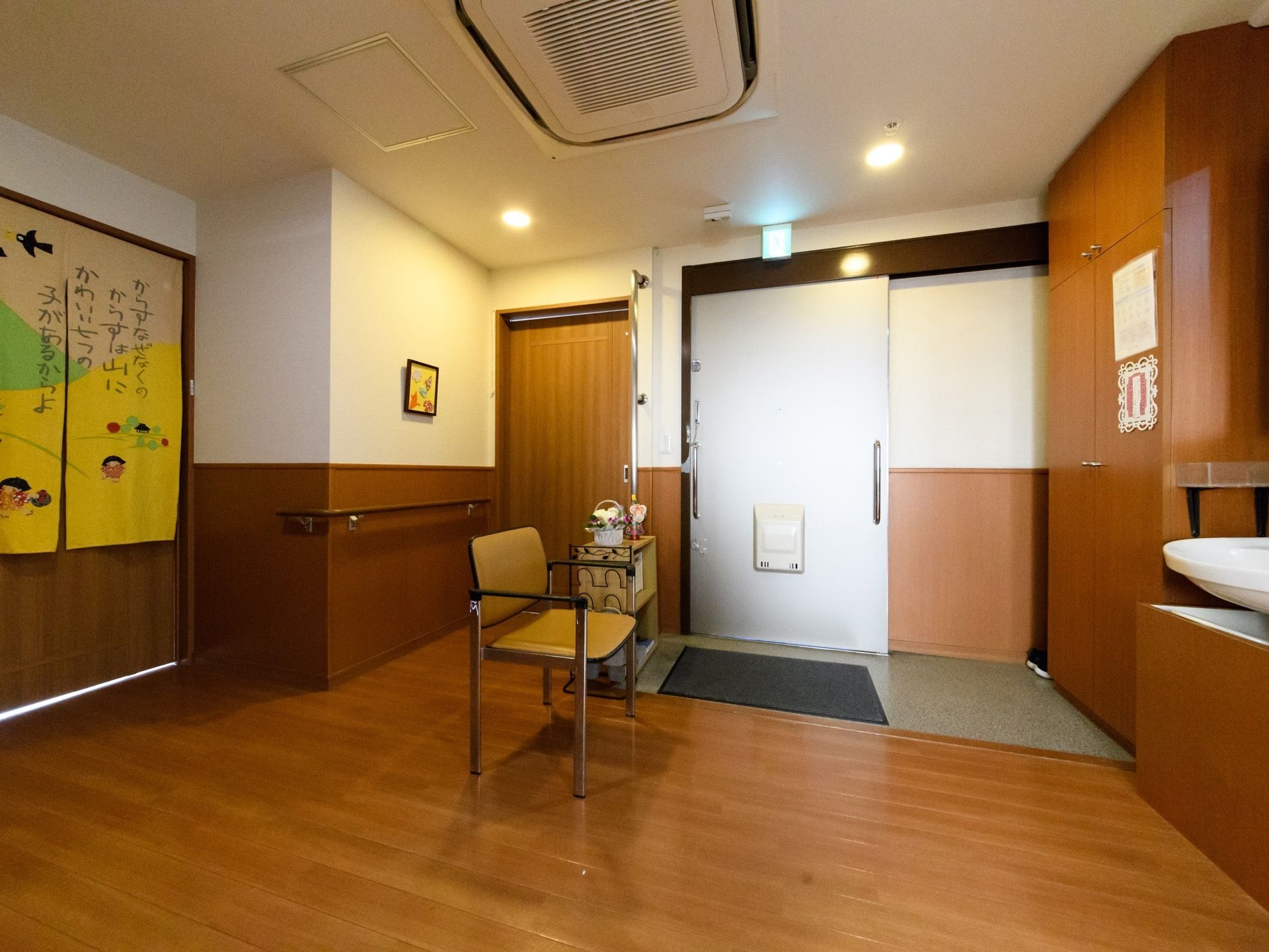 玄関は段差が小さくなるように設計されている。洗面台も近くにあるので手洗いもしやすくなっている。椅子は靴を履くときなどに利用できる。