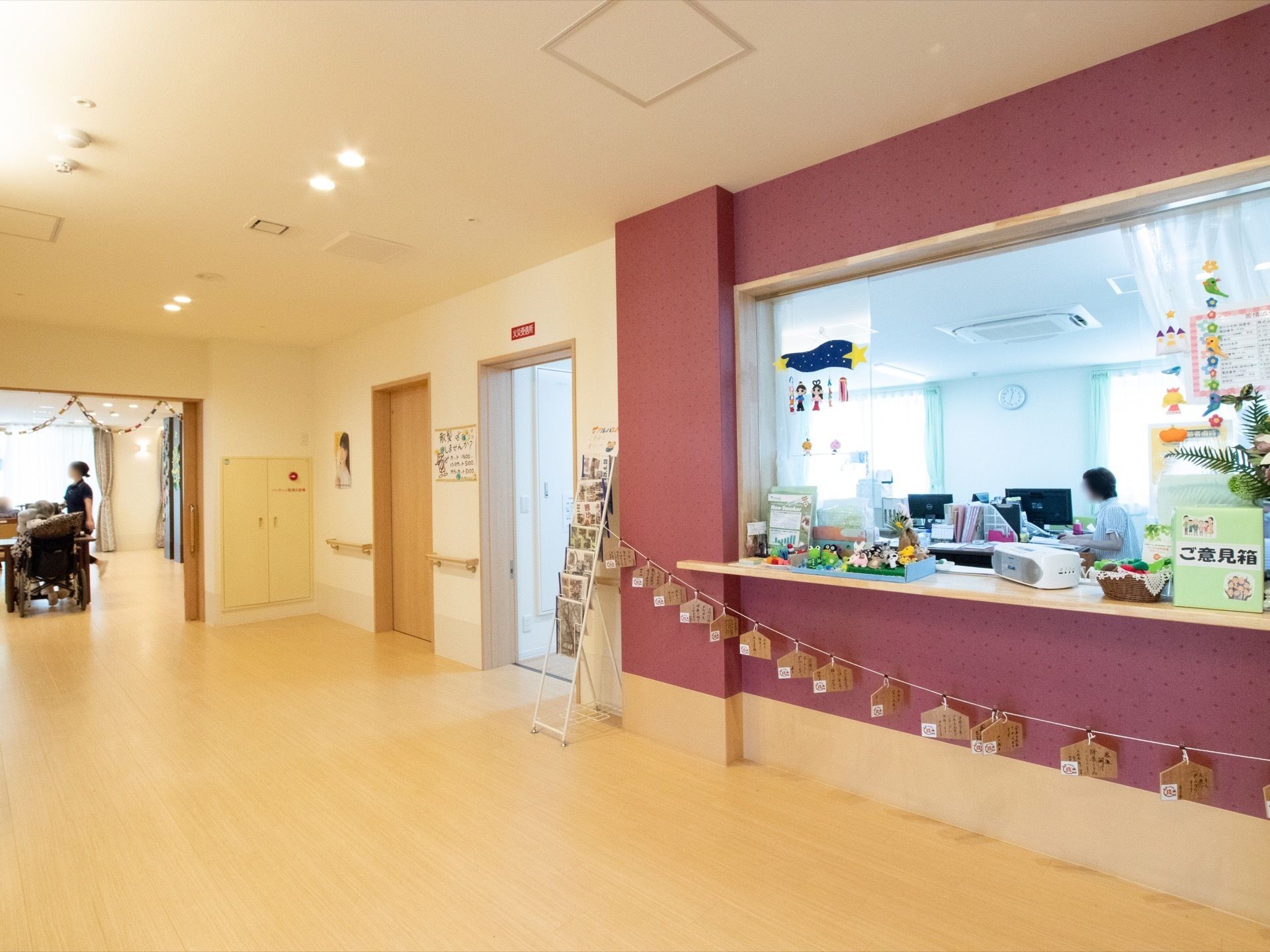 広い通路に面してスタッフルームがあり、ドアがない出入り口がある。窓口の前には、施設への要望や感想を投書できる箱が設置されている。