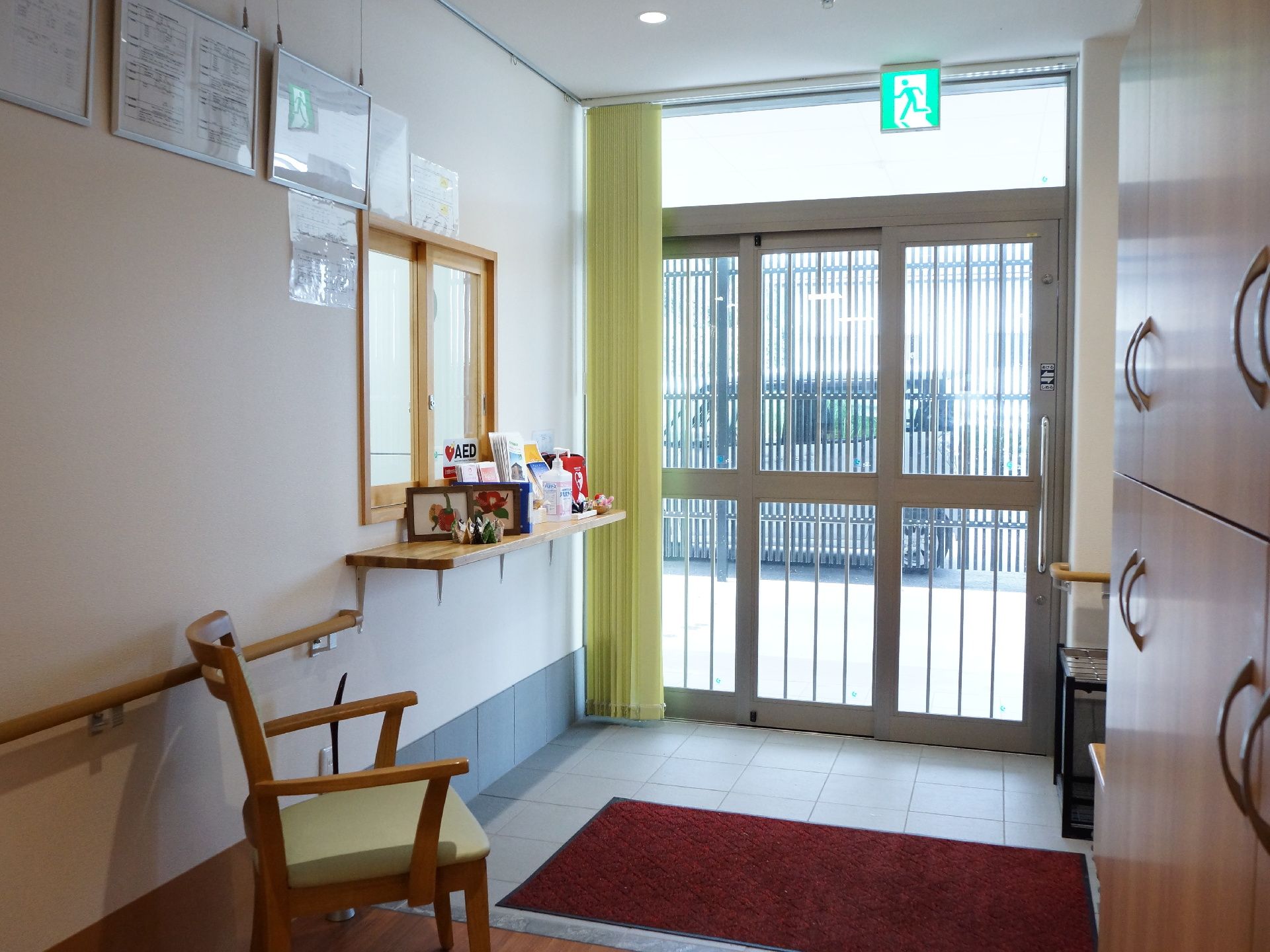 玄関ホールには左側の壁に受付カウンターが設置されている。手前には手すりがあり、ひじ掛け付きの椅子が置かれている。