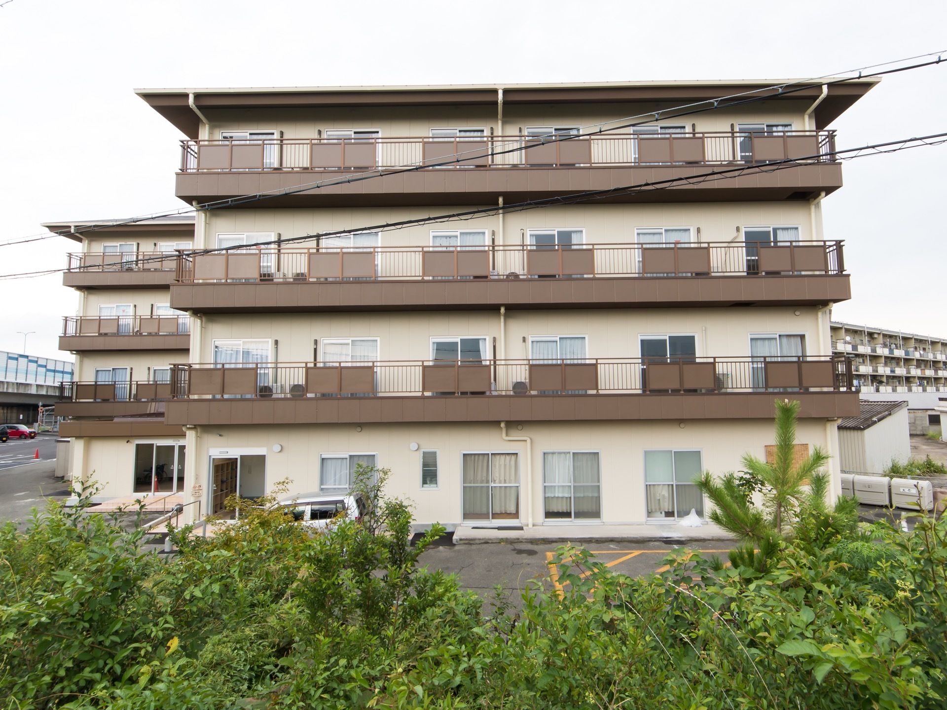 施設は集合住宅のような外観の４階建ての建物である。居室外には、ベランダがある。建物前に駐車場が設けられている。