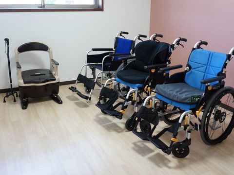 入居者の立ち座り動作補助のため準備された自立型杖と車椅子