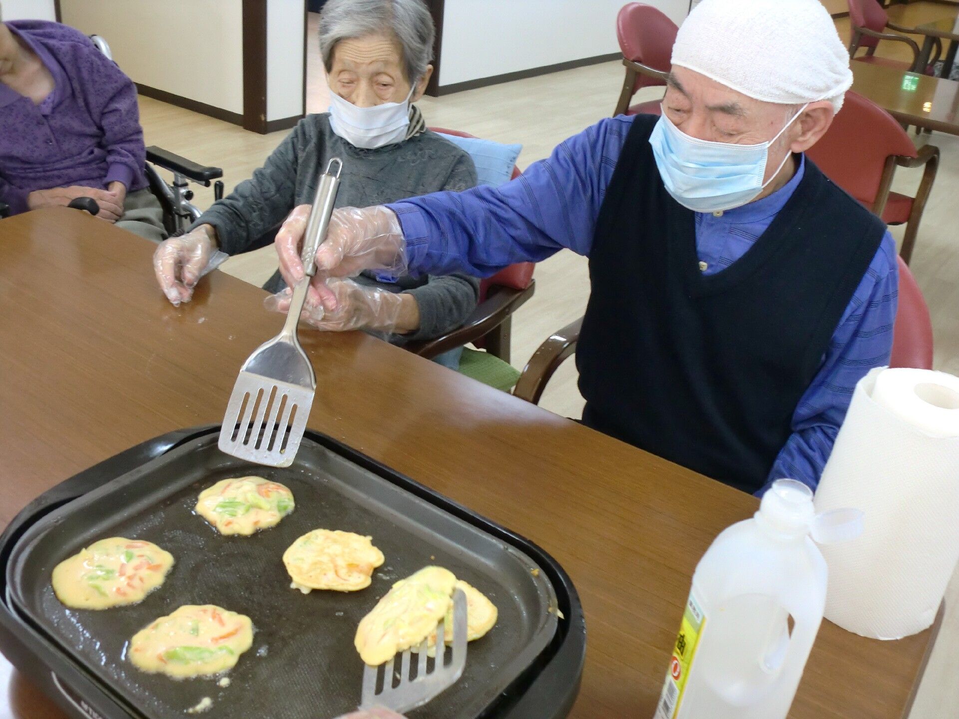 協力しながらホットプレートでお食事作りを楽しむ入居者