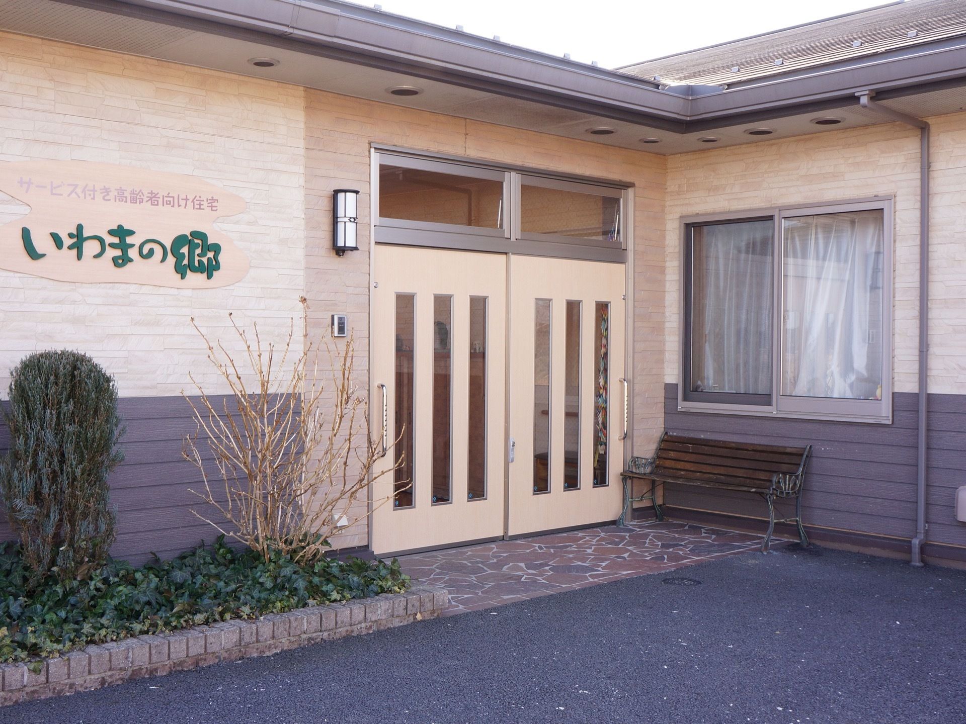 外からみた、入口。壁面に取り付けられた、施設名が印象的。傍らに、ベンチが設置されているので、外で休憩ができる。