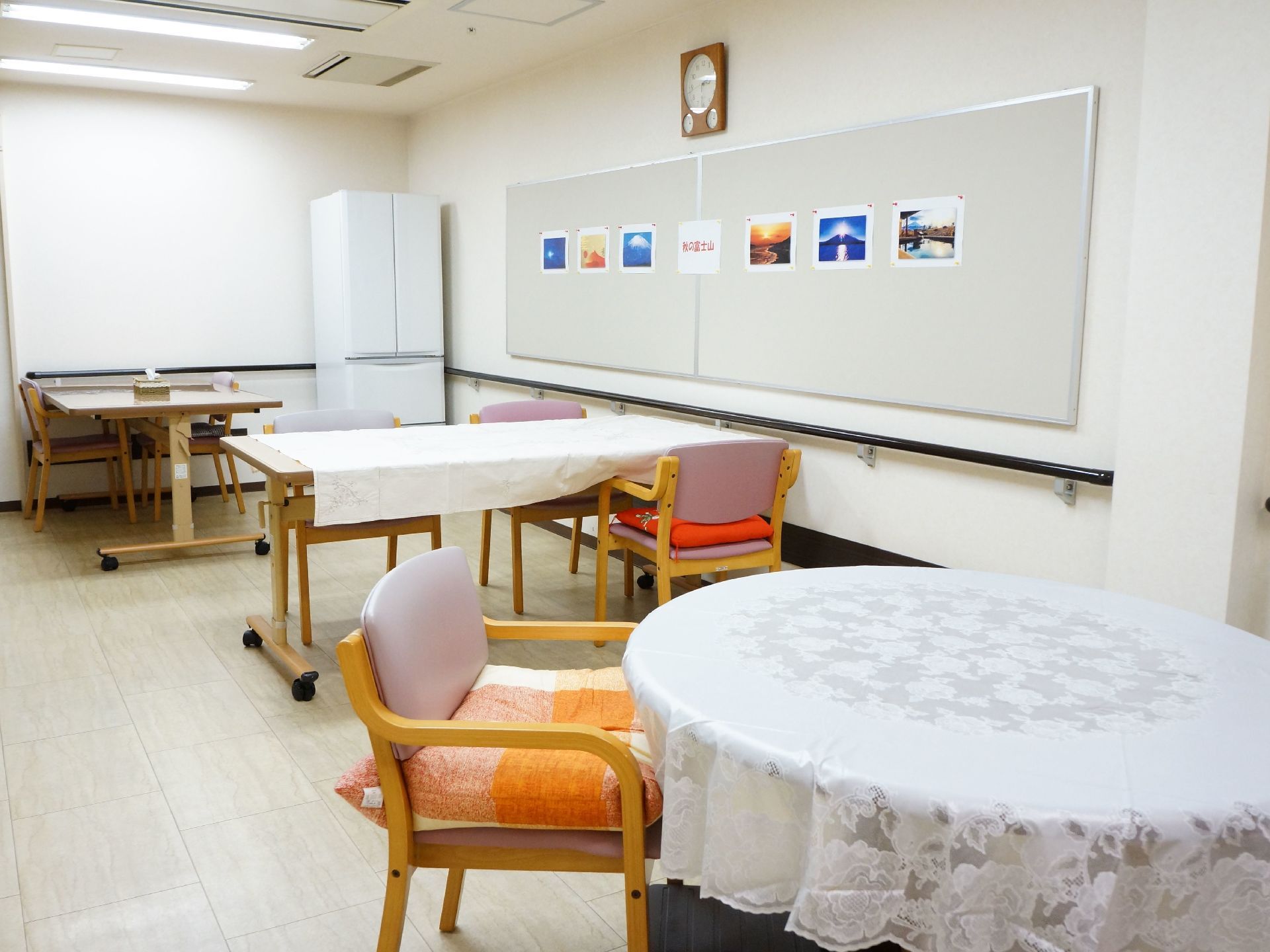 壁全体に手すりが設置されている。円形や長方形のテーブルと椅子が置かれている。天井にはエアコンがある。