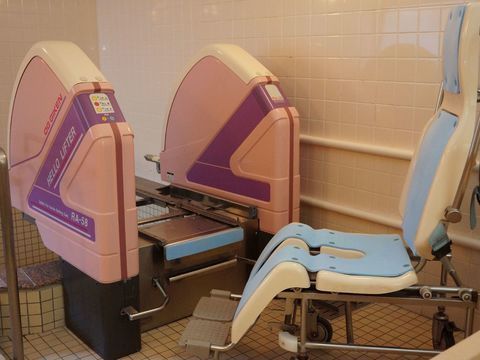 入居者の入浴を介助するリクライニングチェア付き介護用入浴機器