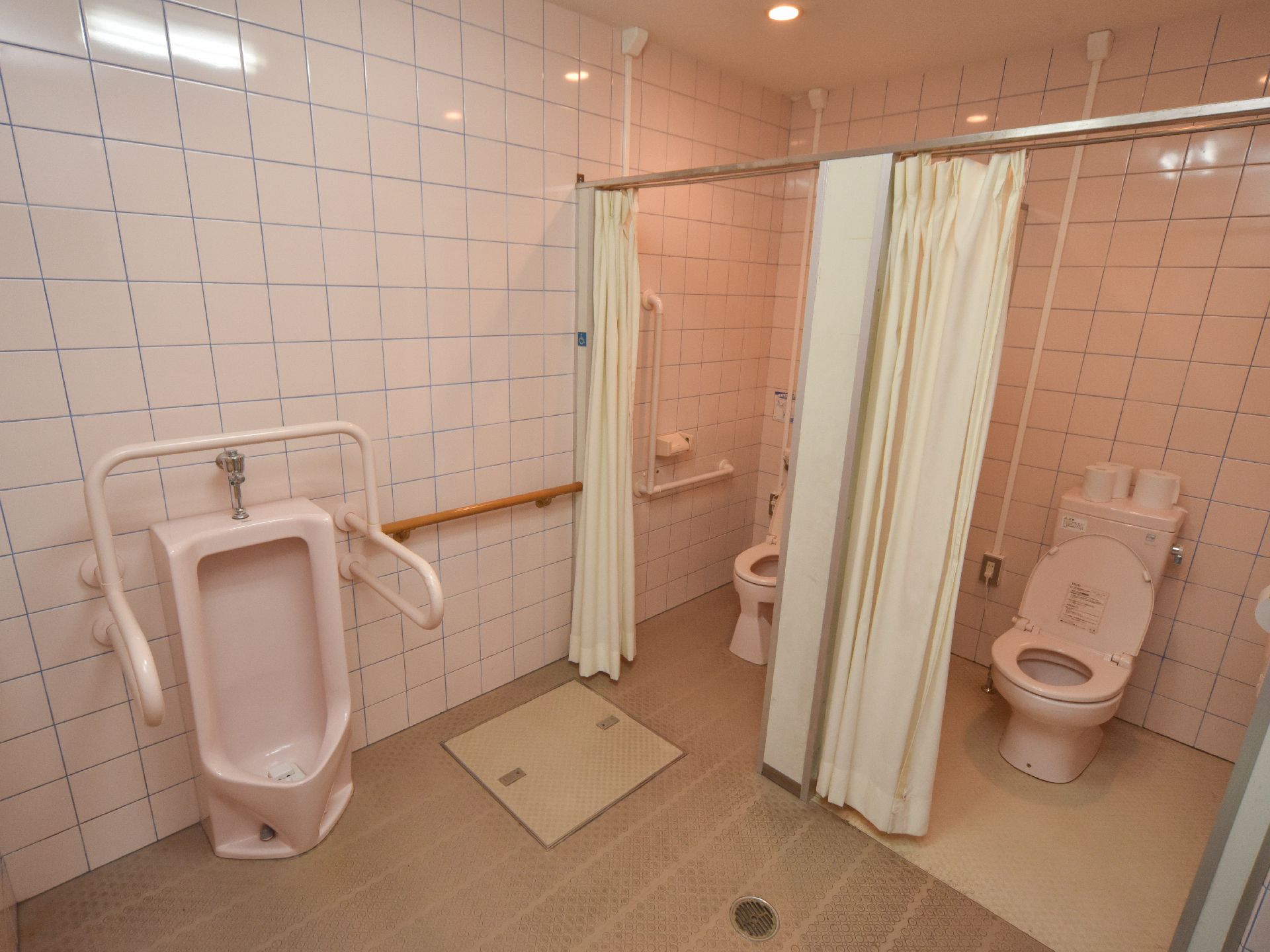 施設内にある、トイレのひとつ。洋式トイレが2つと、男性用便器が1つある。扉はなく、カーテンで仕切ることができる。