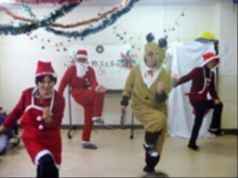 サンタクロースやトナカイの格好で楽しそうに踊るスタッフ