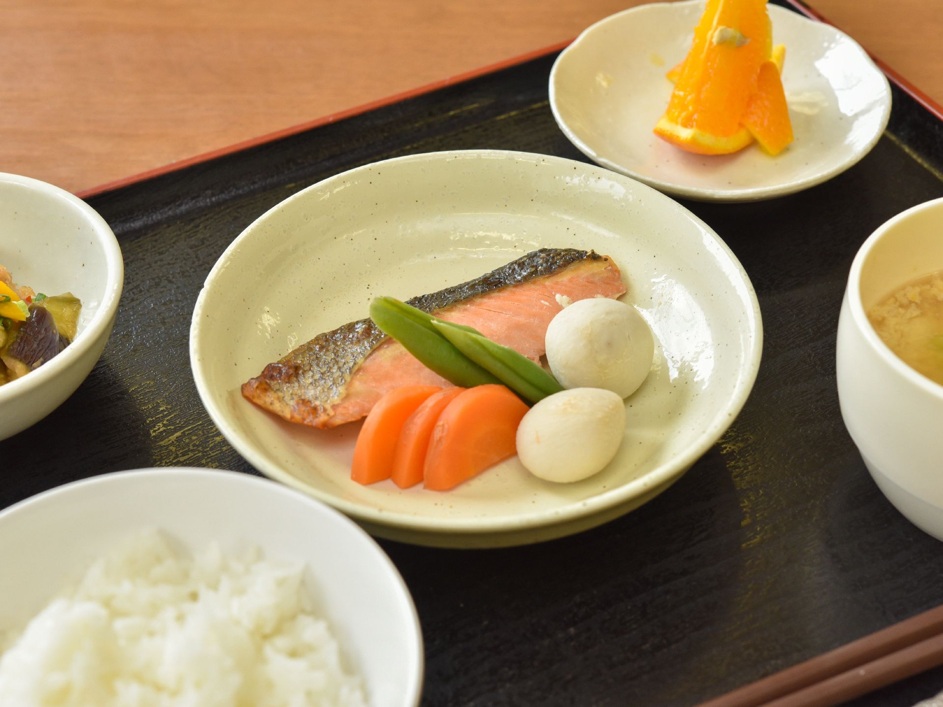 この日は、焼いた鮭がメインのおかずとなっている。鮭の横には、サトイモや人参、いんげん等の野菜がきれいに並んでいる。