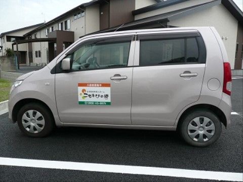 駐車場に停車している小回りが利くコンパクトタイプの送迎車