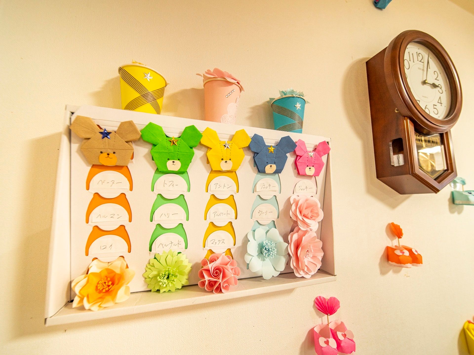 館内の壁に取り入れた手作りのレイアウトである。カラフルな色紙で５つの動物の顔を作り、お花を飾るなど、工夫を凝らしている。