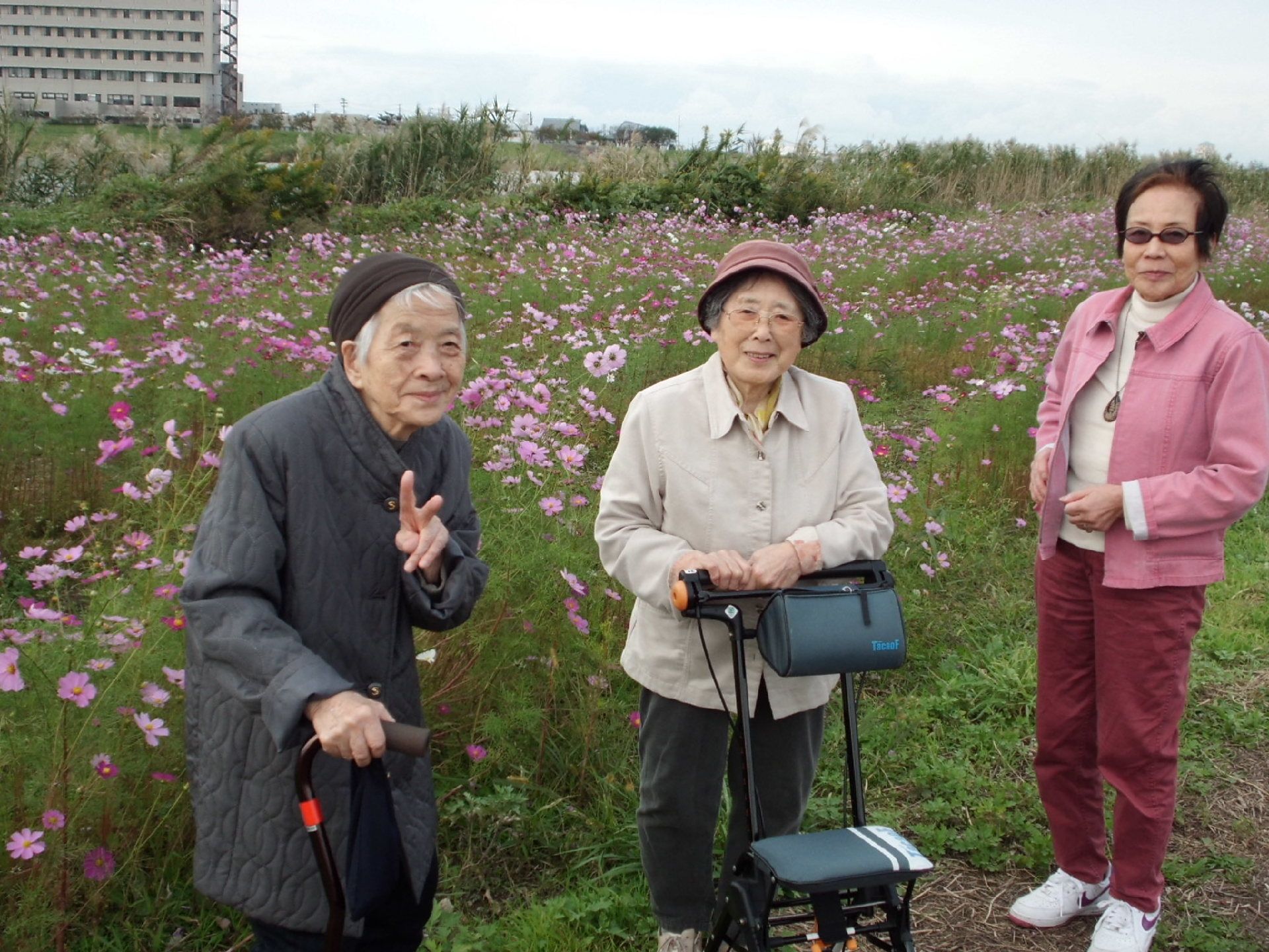 鮮やかな季節の花々に囲まれて笑顔を見せる女性入居者