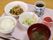 プレートにご飯、みそ汁、メインのおかずやサラダの他に、ゼリーとお茶が置かれている。ゼリーはガラスの小鉢に入っている。