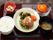 ある日の給食である。おろし掛けハンバーグ、きゅうりの酢の物、野菜サラダ、白ご飯、みそ汁、みかんである。