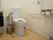 個室内はスペースが広く、洗面台もある。壁や便器脇に手すりが設置されている。トイレットペーパーホルダーは二つ付いている。