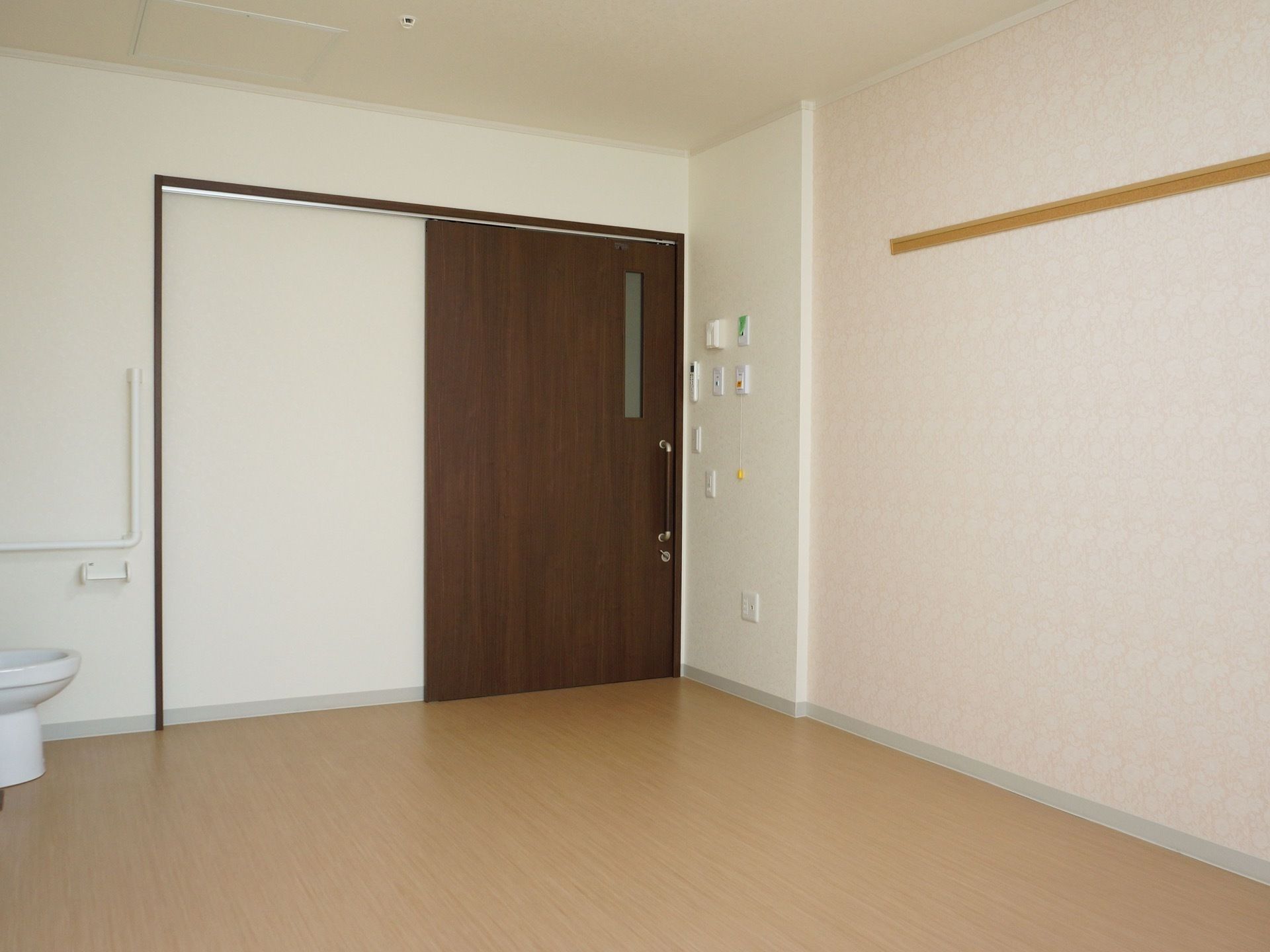 居室の入口は大きく開く引き戸になっている。床は段差のないバリアフリーなので、車椅子でも快適に生活できる。