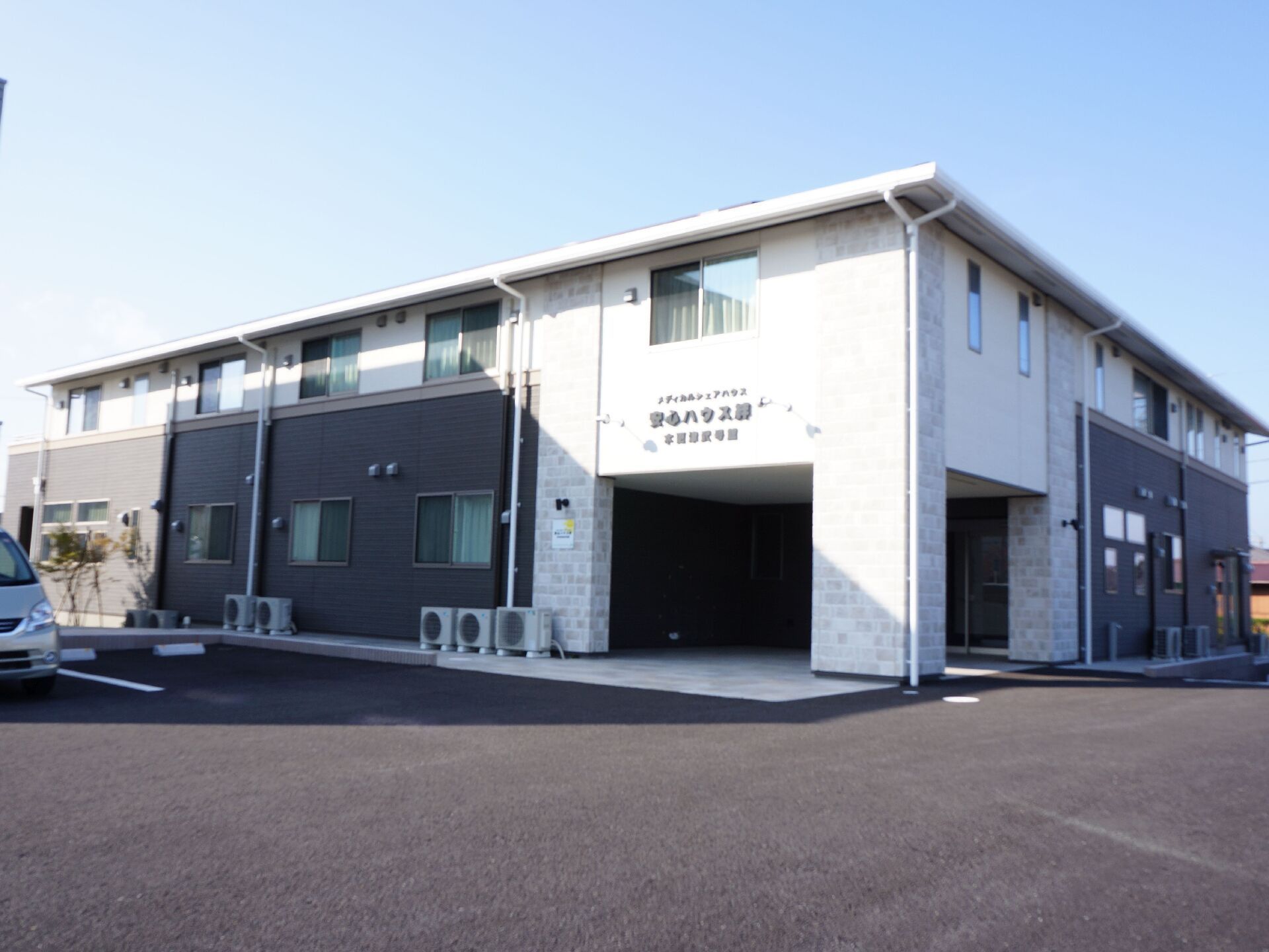 開放的な広々としたエントランスとシックな配色の二階建て施設