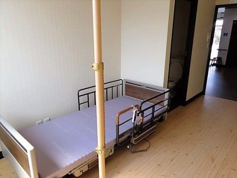 段差のないフラットな床の居室に設置された入居者用ベッド