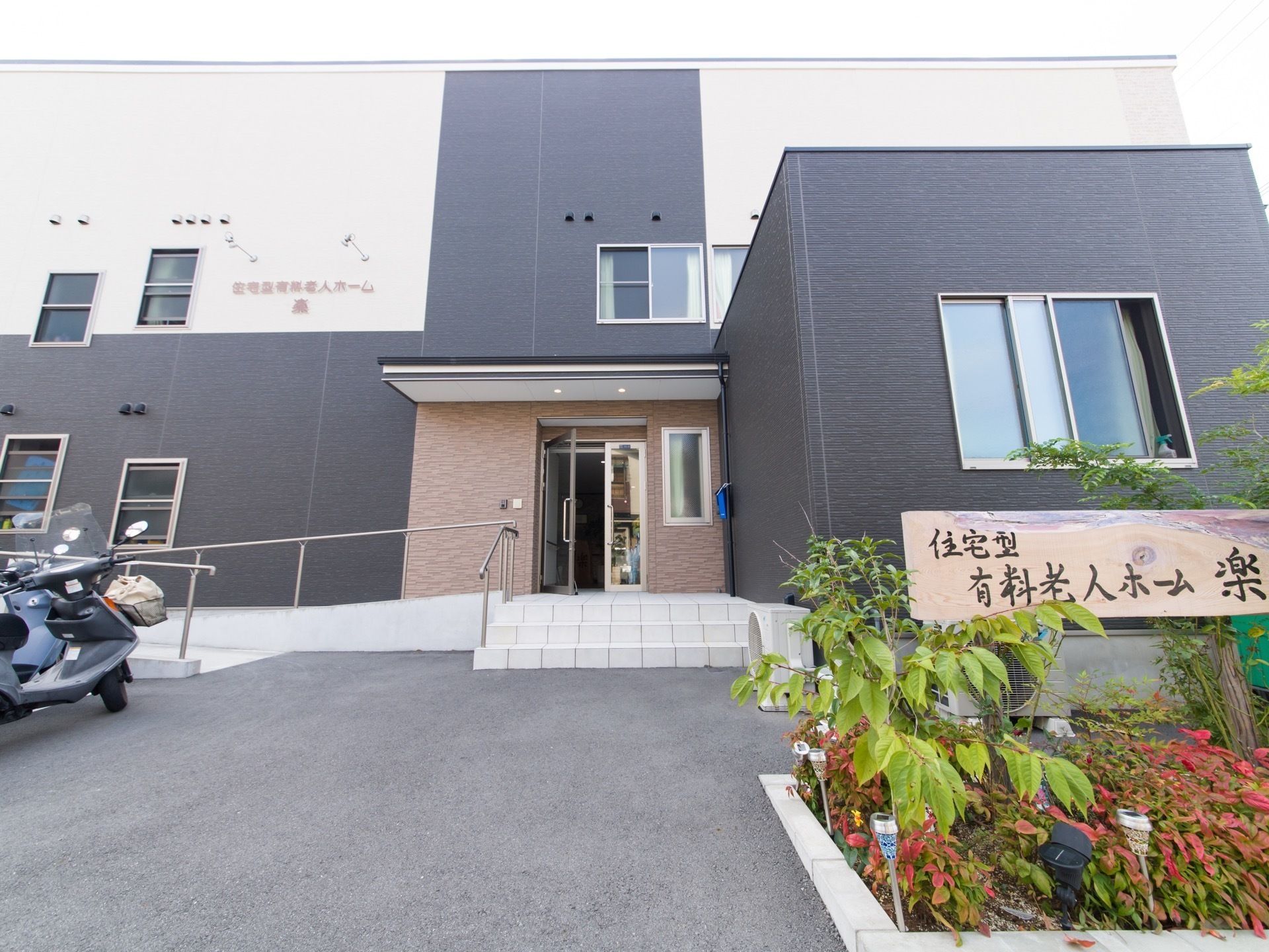 スロープと手すりを完備したエントランスがある二階建ての施設