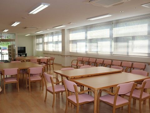 木製テーブルとピンクのひじ掛け椅子が並んだ明るい食堂である。十分な広さがあり、外の景色も見えるので開放的な気分になれる。