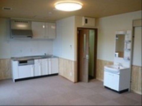 部屋はバリアフリーになっており、キッチンや洗面台が付いている。壁の下側は木目調になっており、上側は白くなっている。