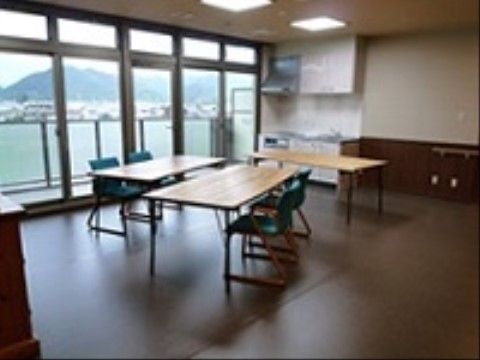 キッチンにはレンジフードが付いている。テーブルと椅子が用意されており、自由に動かすことができる。大きな窓から外の景色が見える。