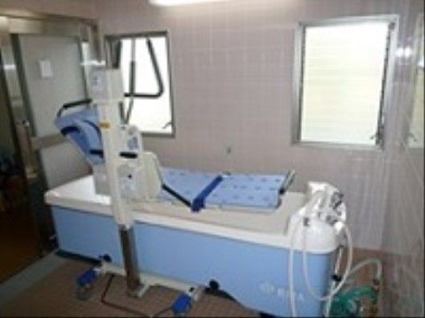 機械浴室には、座ったままの姿勢でも安全に入浴のできる介護浴槽の設備がある。座椅子のようなものを支えているリフトが見える。