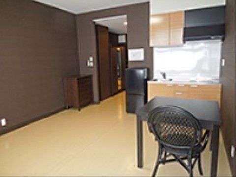室内には、床の上にテーブルと椅子が１脚、ミニタンス、冷蔵庫が置かれており、ミニキッチンが設置されている。