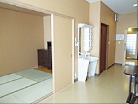 居室内は洋室と和室が区切られており、洋室には障子の窓がある。洗面台、テーブルが置かれ、和室には畳が敷かれ、タンスが置かれている。