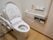 壁や便座の横に手すりが備え付けられたトイレがある。操作パネルの横には緊急用のナースコールも設置されている。