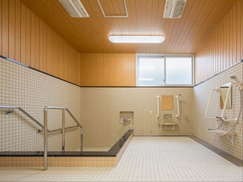 入居者様が共有している浴室には、シャワーがいくつか用意されている。手すりを使って湯に入れるように設計されている。