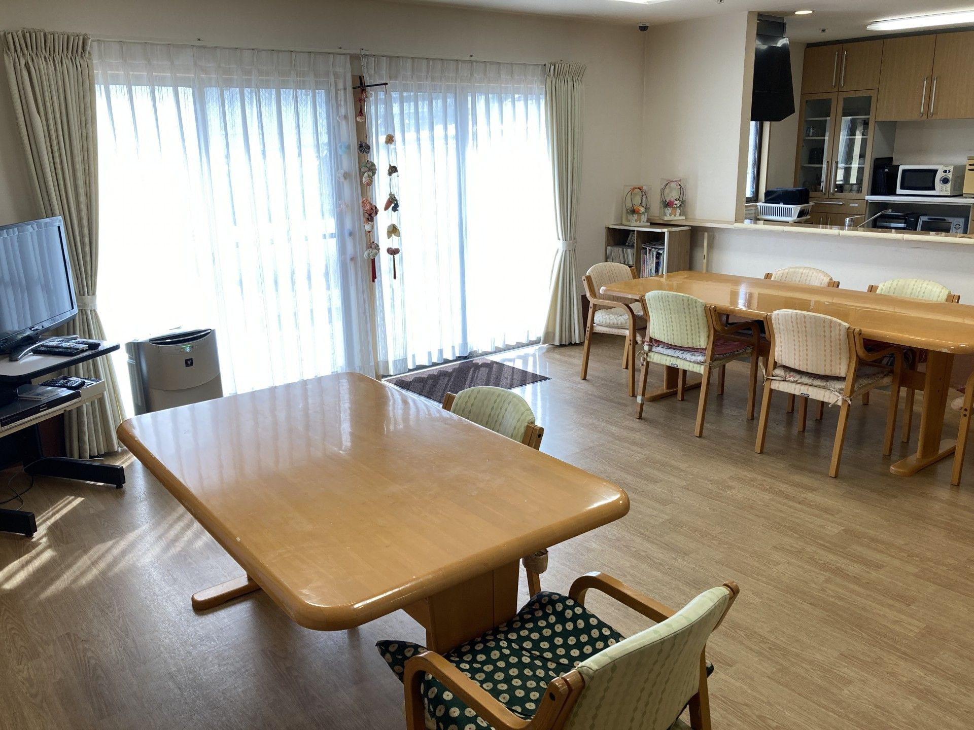 机に料理があり、お茶碗と箸を持っている笑顔の高齢者たち
