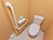 トイレの個室内の壁紙は明るい山吹色である。Ｌ字型の手すり、トイレの操作パネル、ペーパーホルダー、呼出ボタンが左側の壁に設置されている。