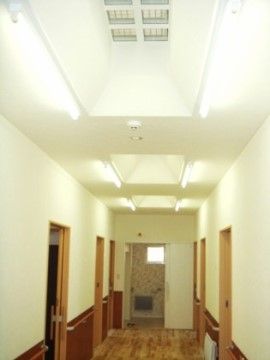 天井が吹き抜けになっており開放感が感じられる。壁や天井は白で床は木目調なので落ち着いた雰囲気の空間である。
