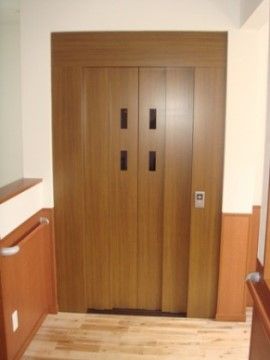 シックなブラウンのエレベーターである。エレベーターの呼び出しボタンは低い位置にあり、どなたでも操作しやすいようになっている。