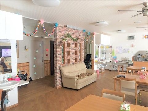 輪飾り、ソファ、ダイニングテーブルセットがある共有スペース