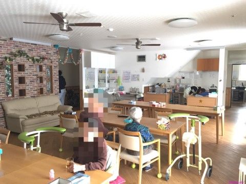 広いダイニングルームで座ってくつろいでいる高齢者たち