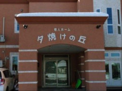 ブラウンの壁がおしゃれな建物。玄関先の屋根には施設名が取り付けられている。雨の日の出入りも楽にできる。