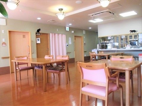 椅子やカーテンがピンク色で統一されている共有スペース