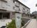 入り口にガラス製の自動ドアが設置された、3階建ての建物の前には、その建物と建物周辺が記載された地図が設置されている。